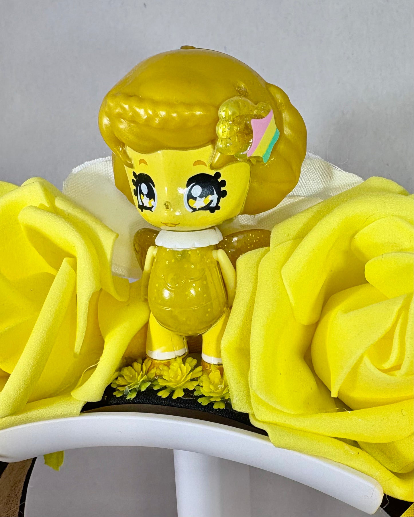 Yellow fairy toy figure and yellow flowers on a festival crown headband