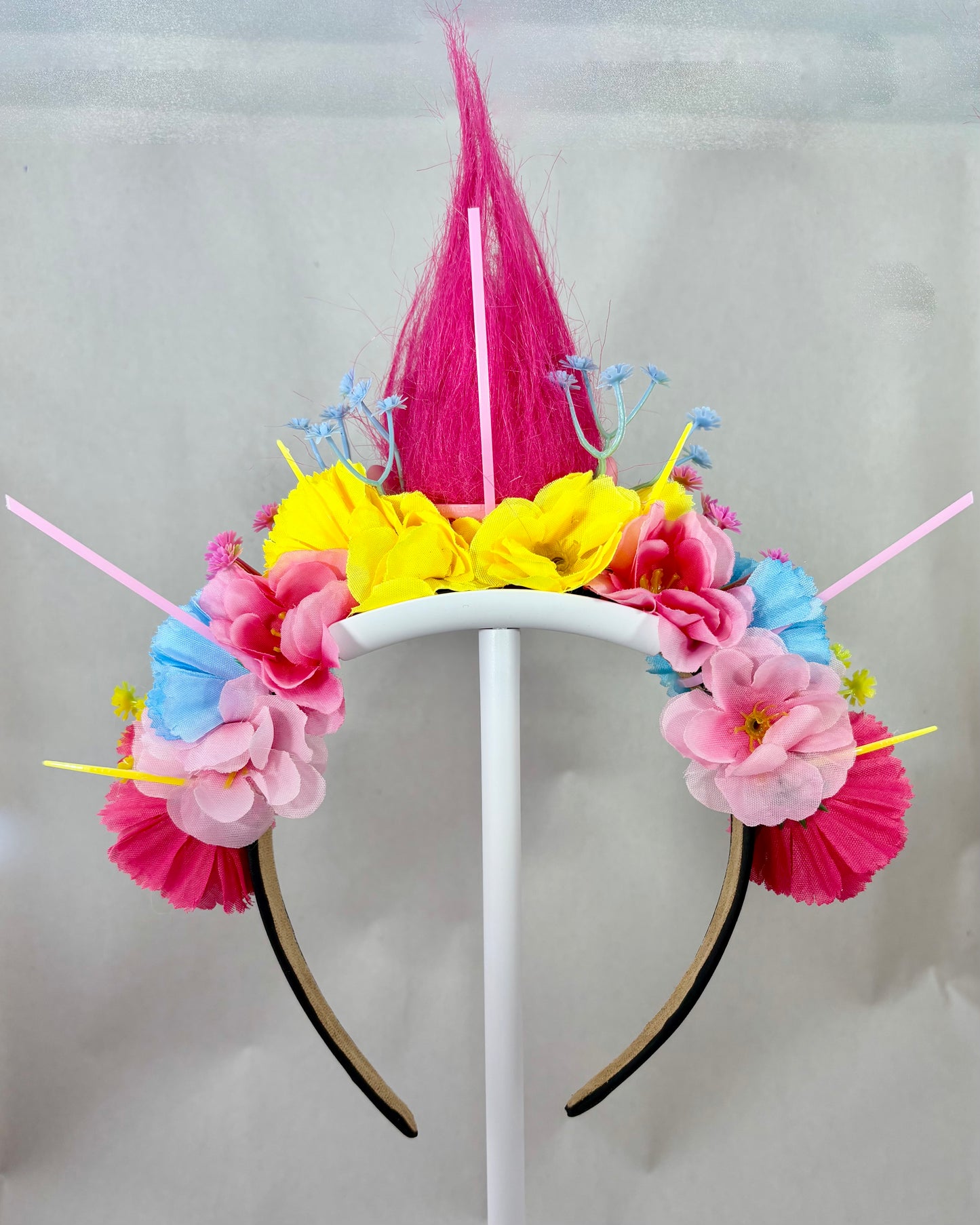 Back of a colourful flower headband with pink, yellow, and blue flowers
