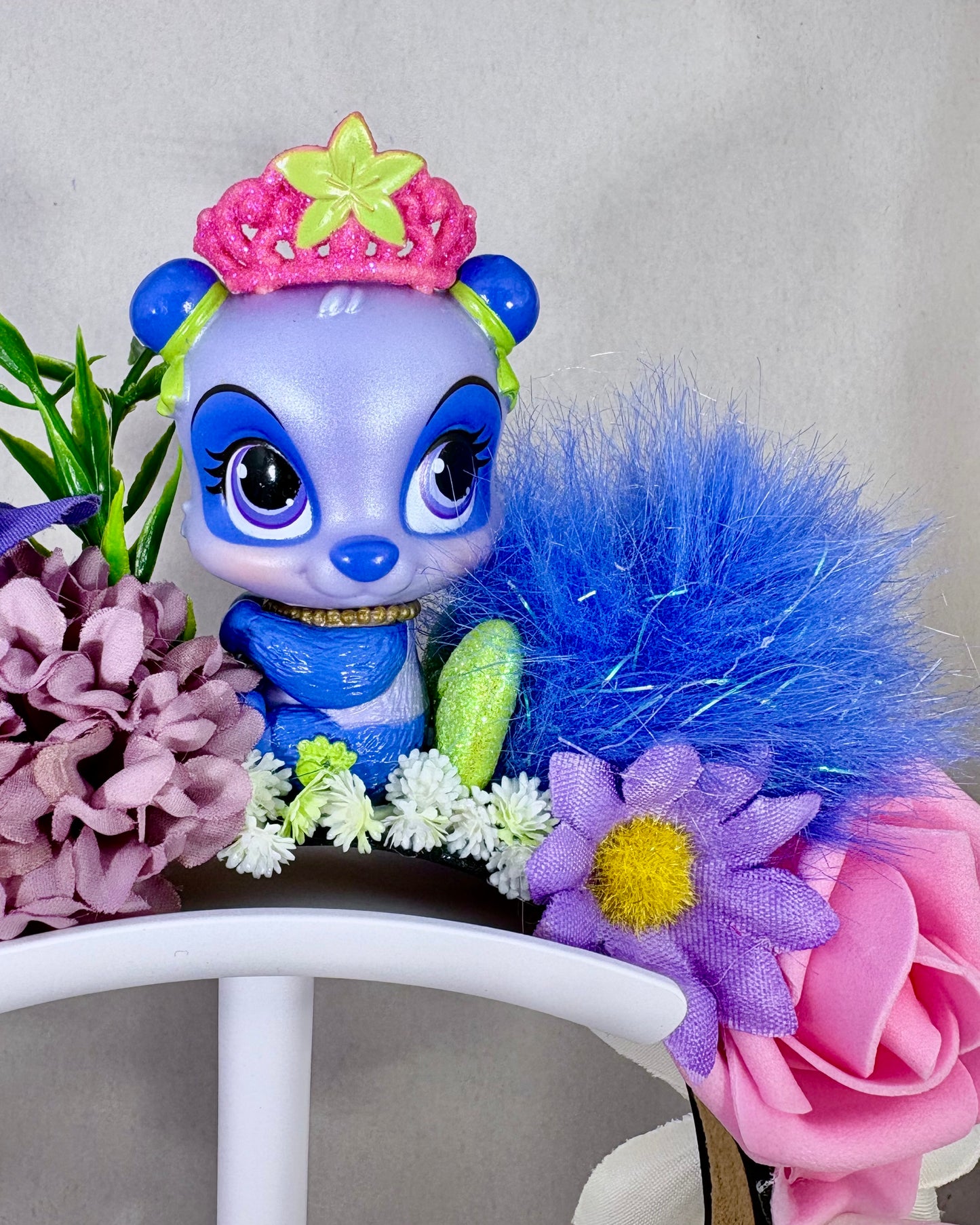 Close up of Colourful floral headband with a small purple panda toy figure