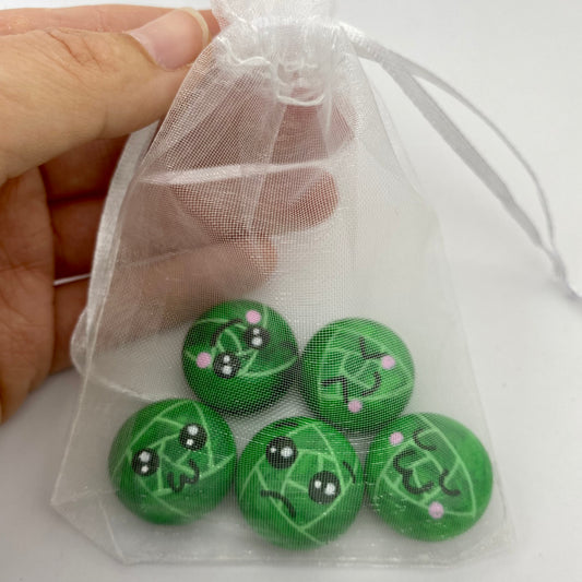 5 Hand painted tiny sprout pebbles each with a different cute faced expression in an organza bag
