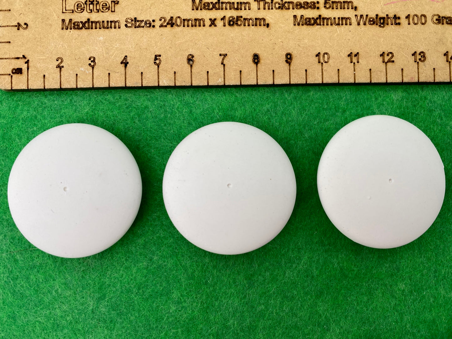 4cm white circular plaster pebbles, each with a tiny centre hole to help with painting mandalas. Photographed next to a ruler