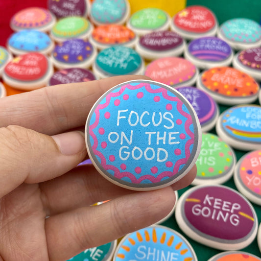Colourful Hand painted pebble with the words Focus on the Good written on