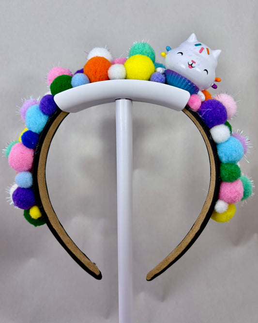 Colourful pom-pom headband with a cartoon cat character toy