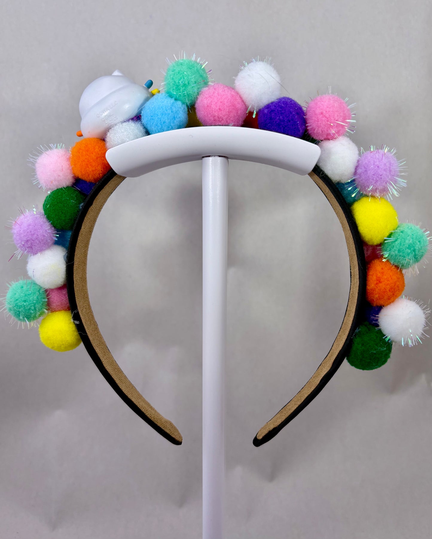 Back of Colourful pom-pom headband with a cartoon cat character toy