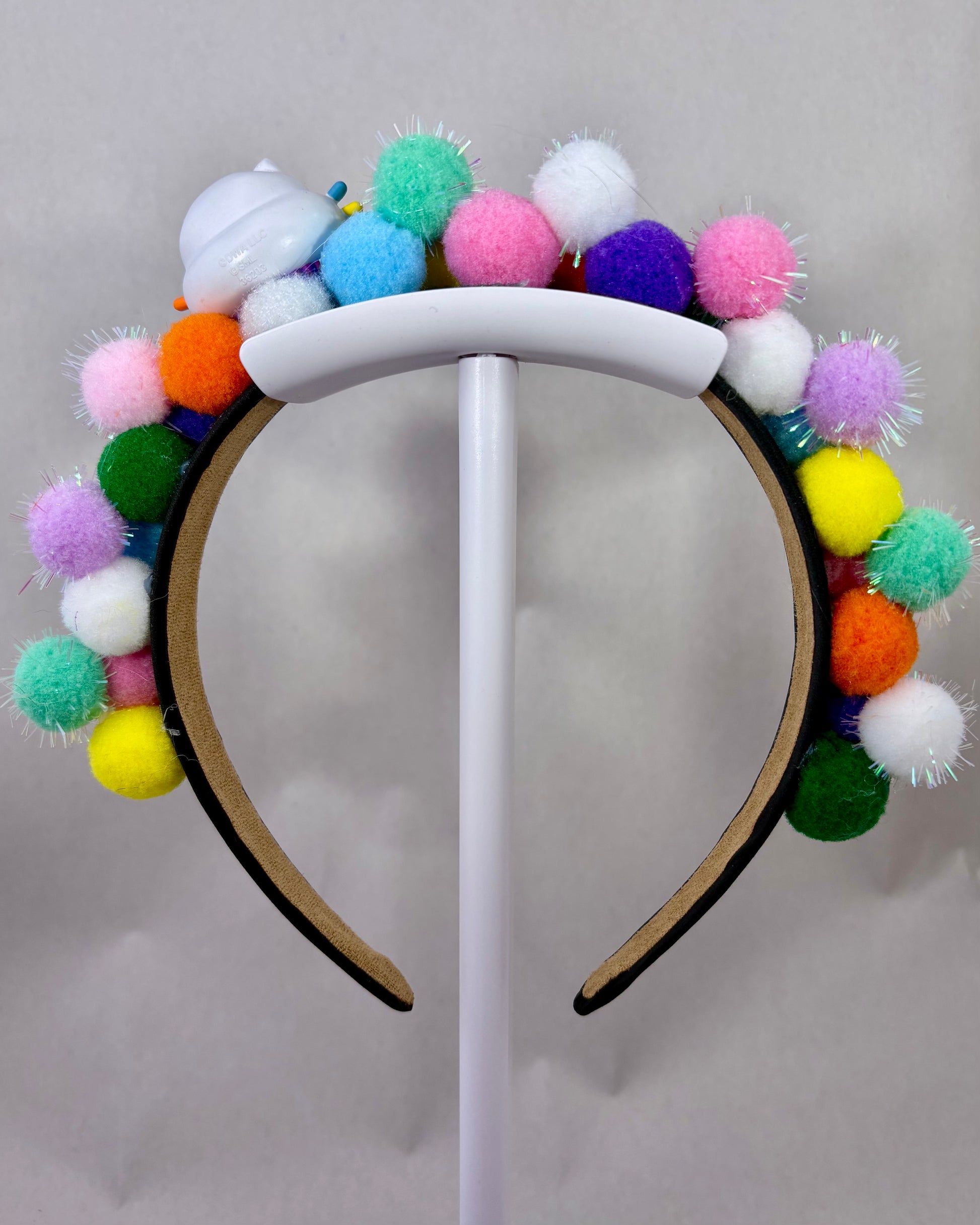 Back of Colourful pom-pom headband with a cartoon cat character toy