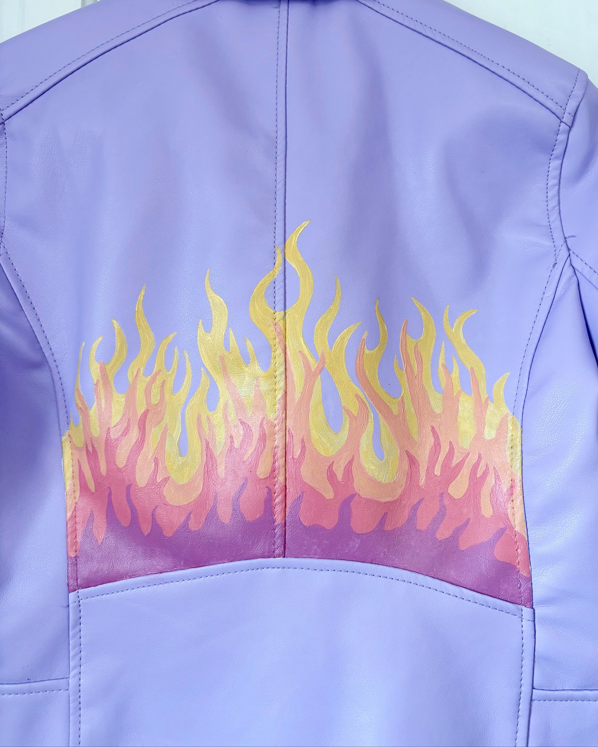 Close up of back panel on Lilac PU leather jacket with painted flame design on