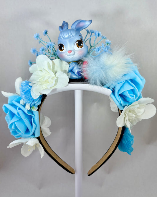 Decorative headband with blue and white flowers and a blue rabbit toy in the centre