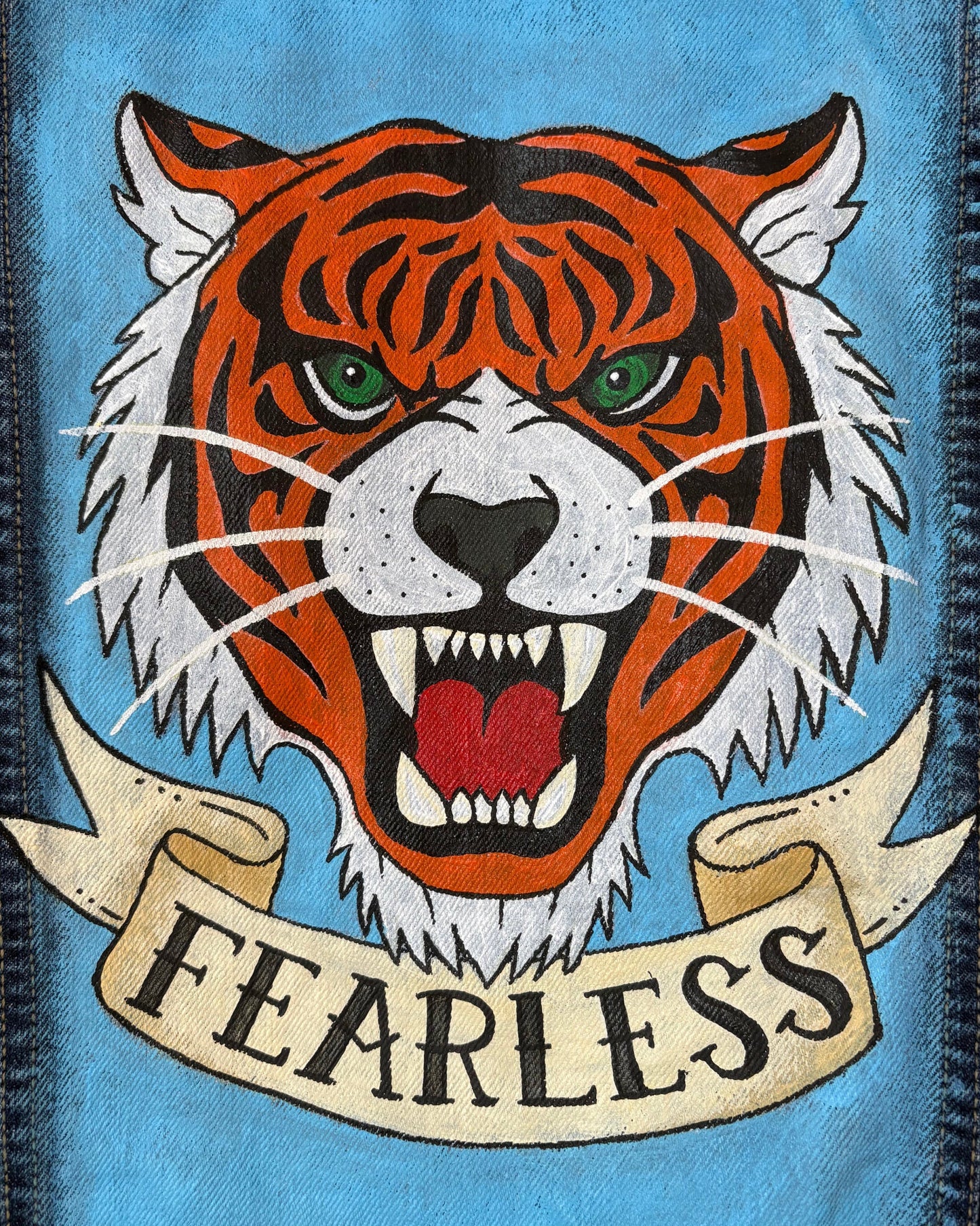 Close up of jacket panel with painted flash style tiger face with it's mouth open and the word Fearless written underneath on a banner