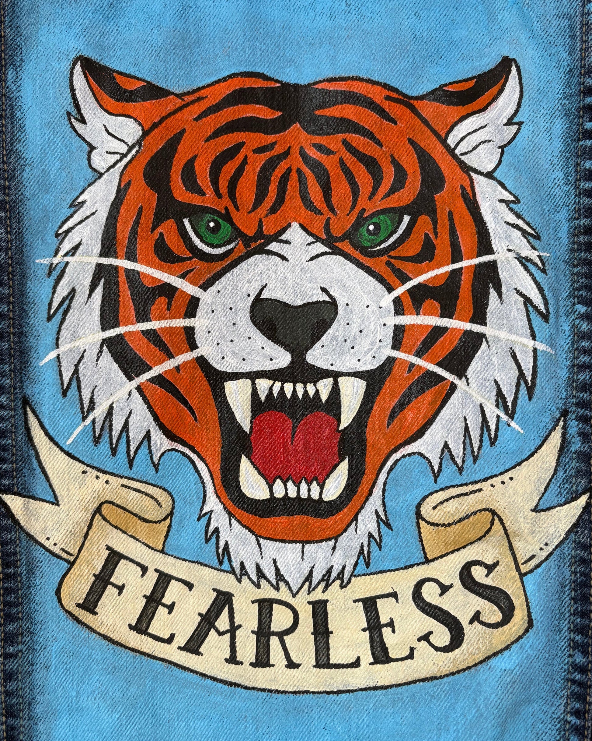 Close up of jacket panel with painted flash style tiger face with it's mouth open and the word Fearless written underneath on a banner
