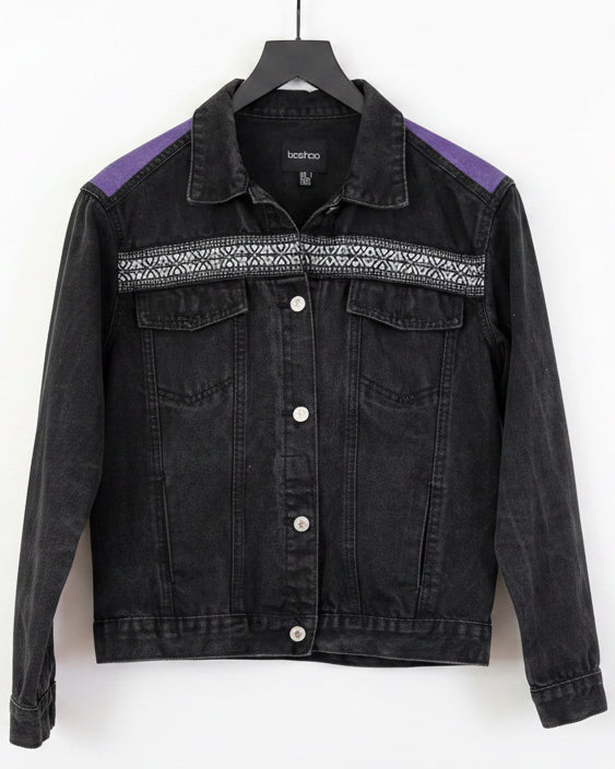 Black denim jacket with embroidered ribbon across the chest