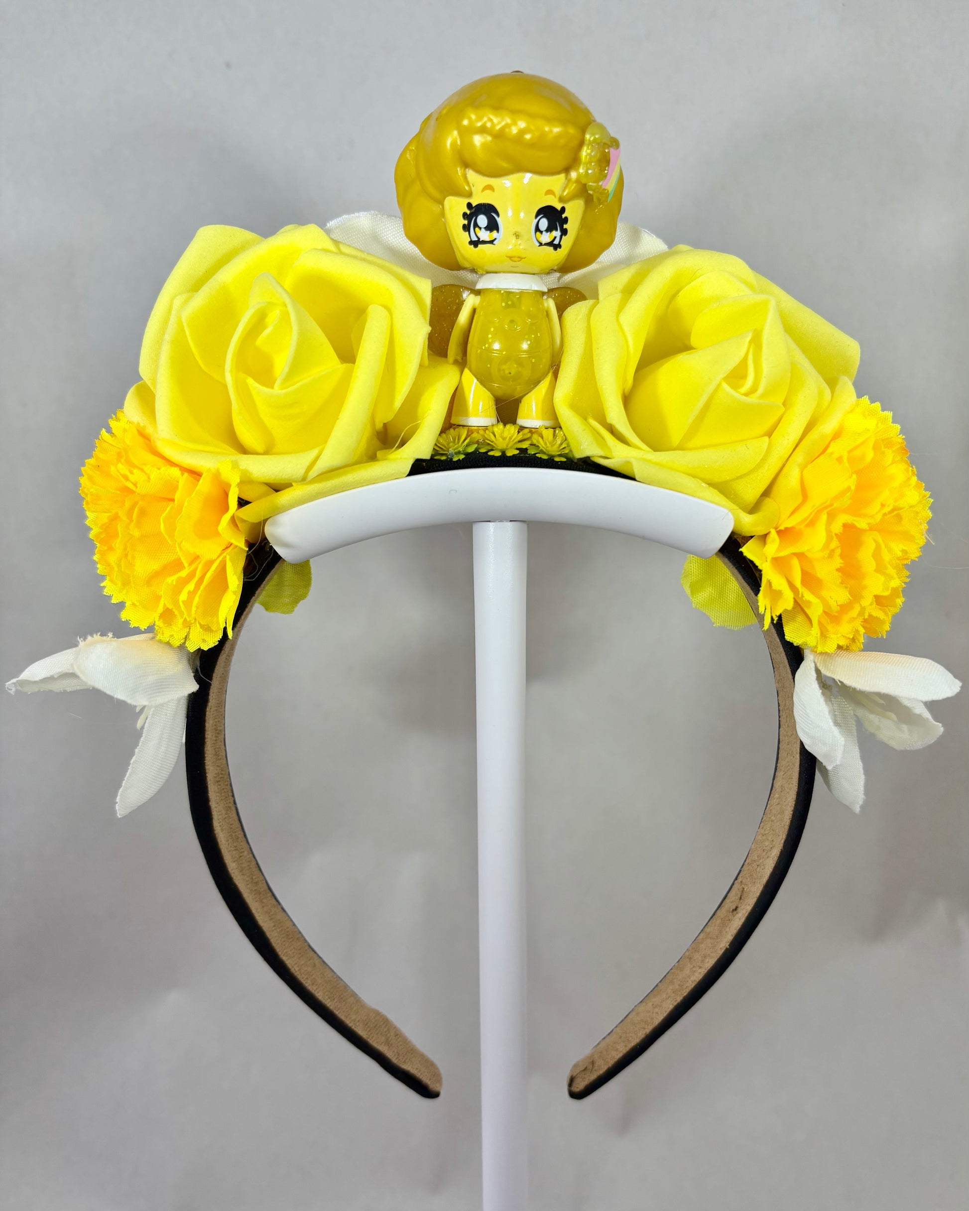 Yellow fairy toy figure and yellow and white flowers on a festival crown headband