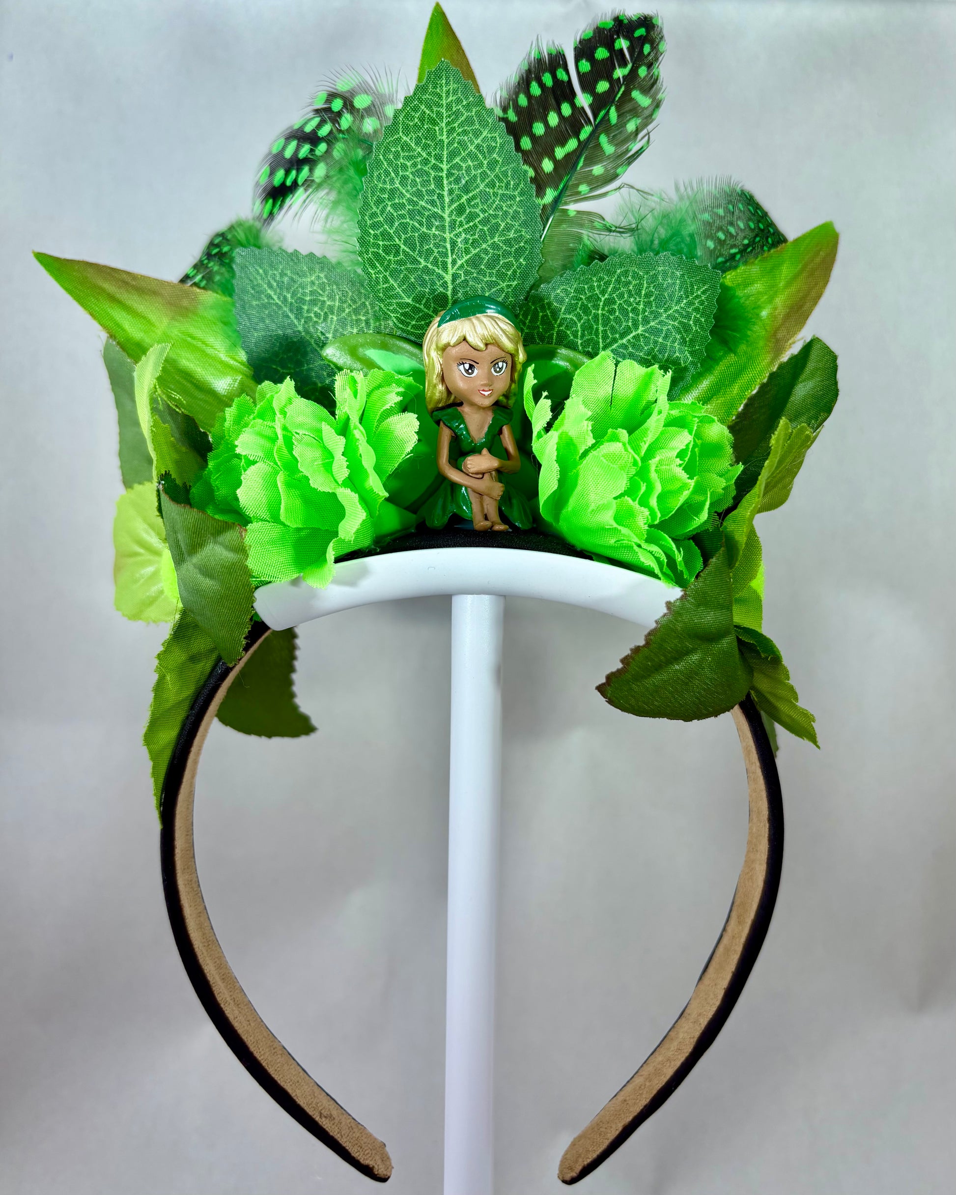Green leafy headband with a small fairy toy sitting in the middle