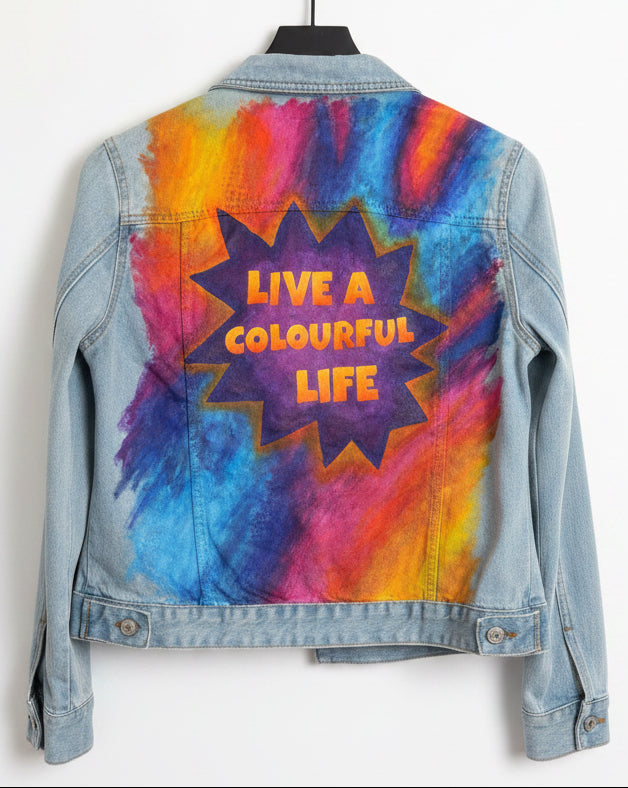Denim jacket with colourful graffiti style design and 'Live a Colourful Life' text painted in a purple starburst
