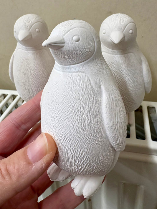 White penguin figurine held by a hand