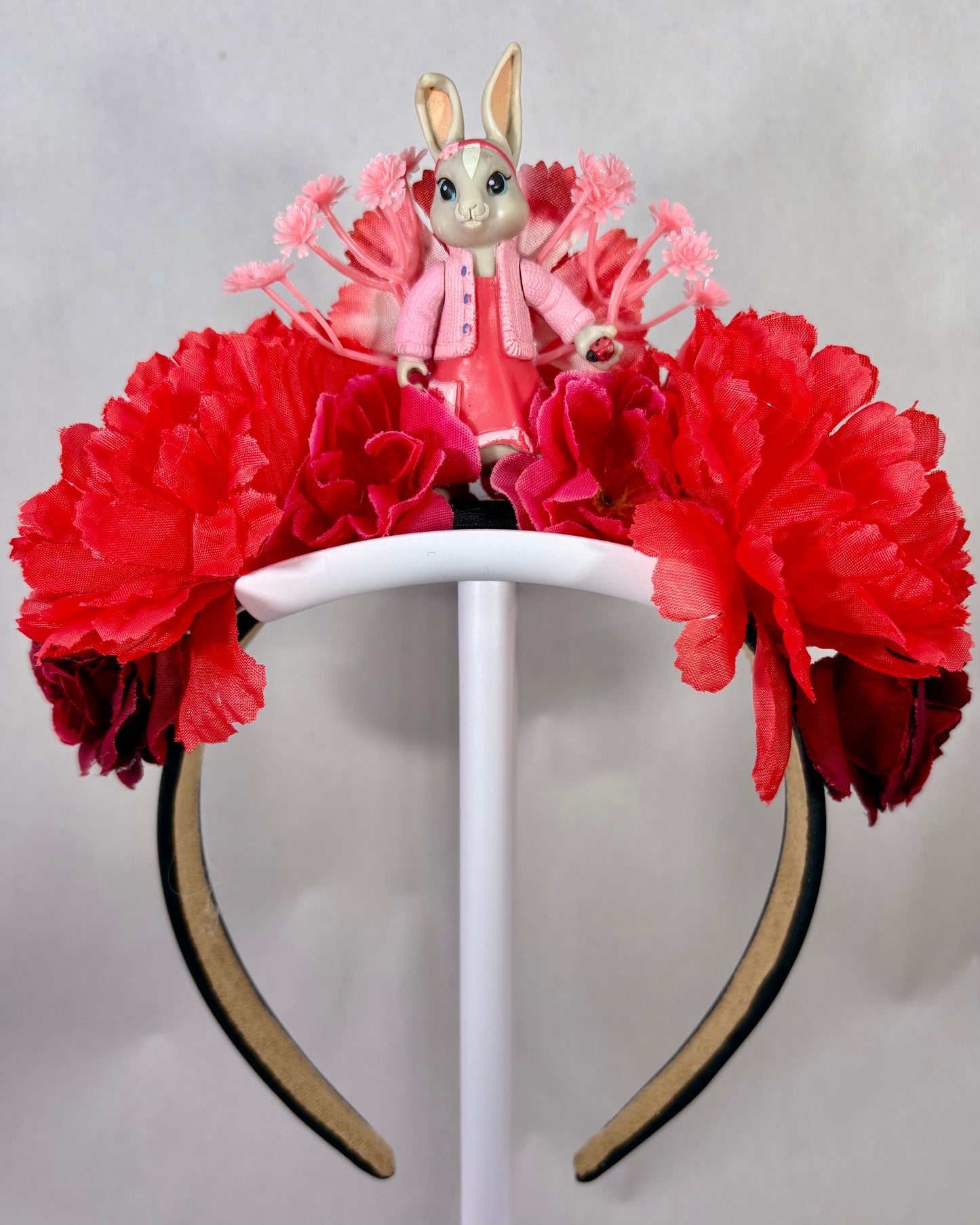 Headband with red flowers and a small toy rabbit figure