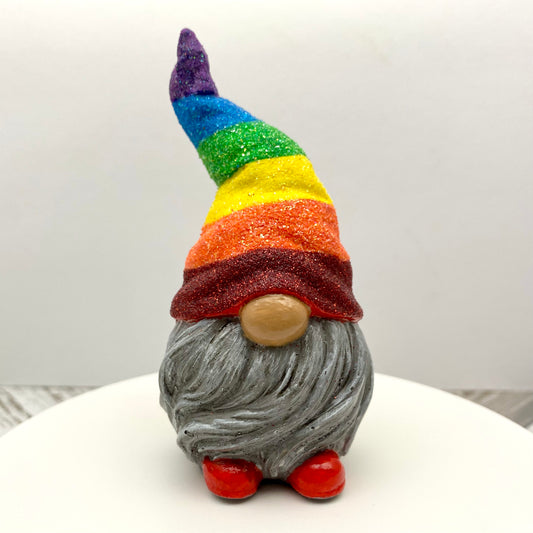 Small hand painted gonk statue with a Glittery Rainbow hat, grey beard and red shoes. Front view.