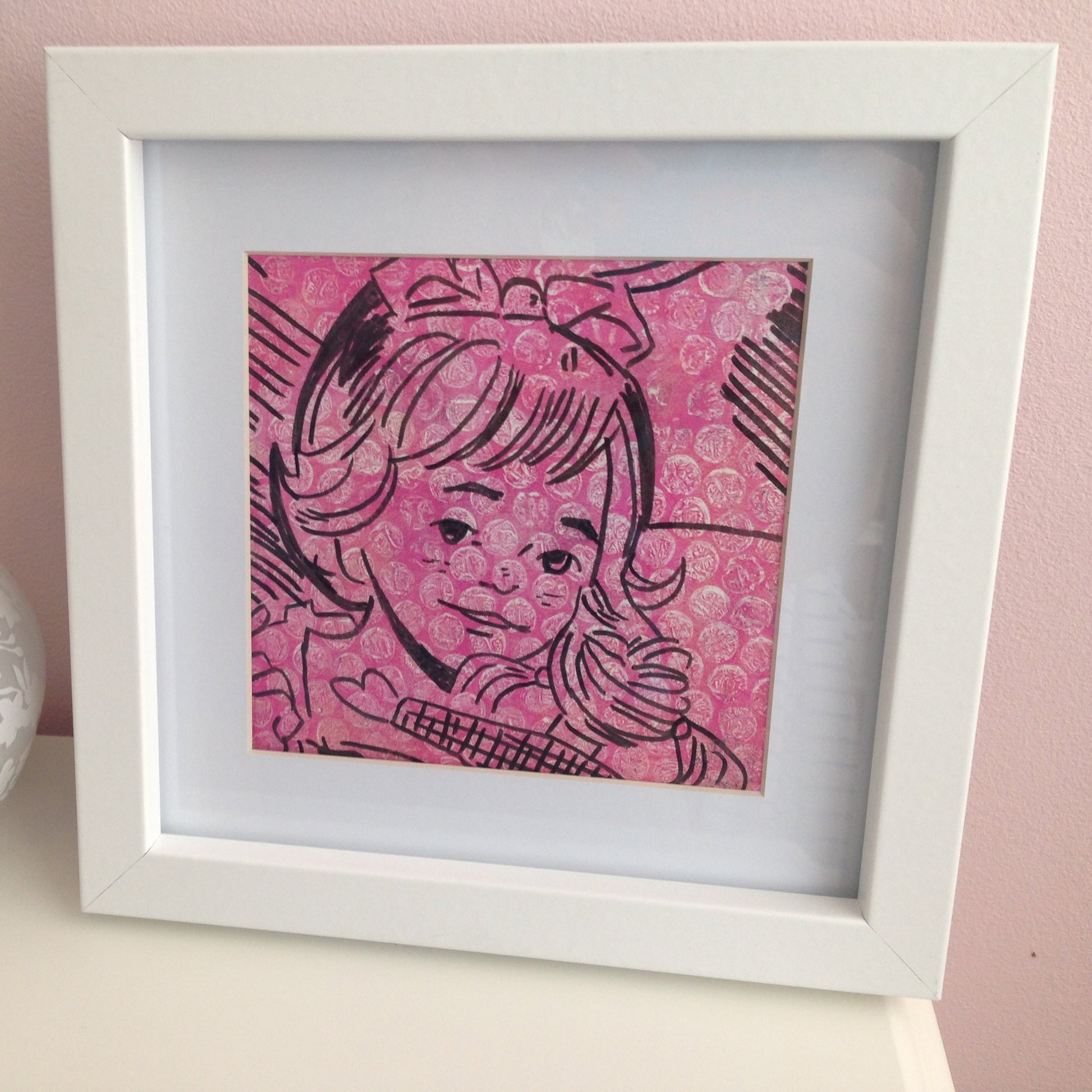 Framed pink and black monoprint of a vintage inspired female character