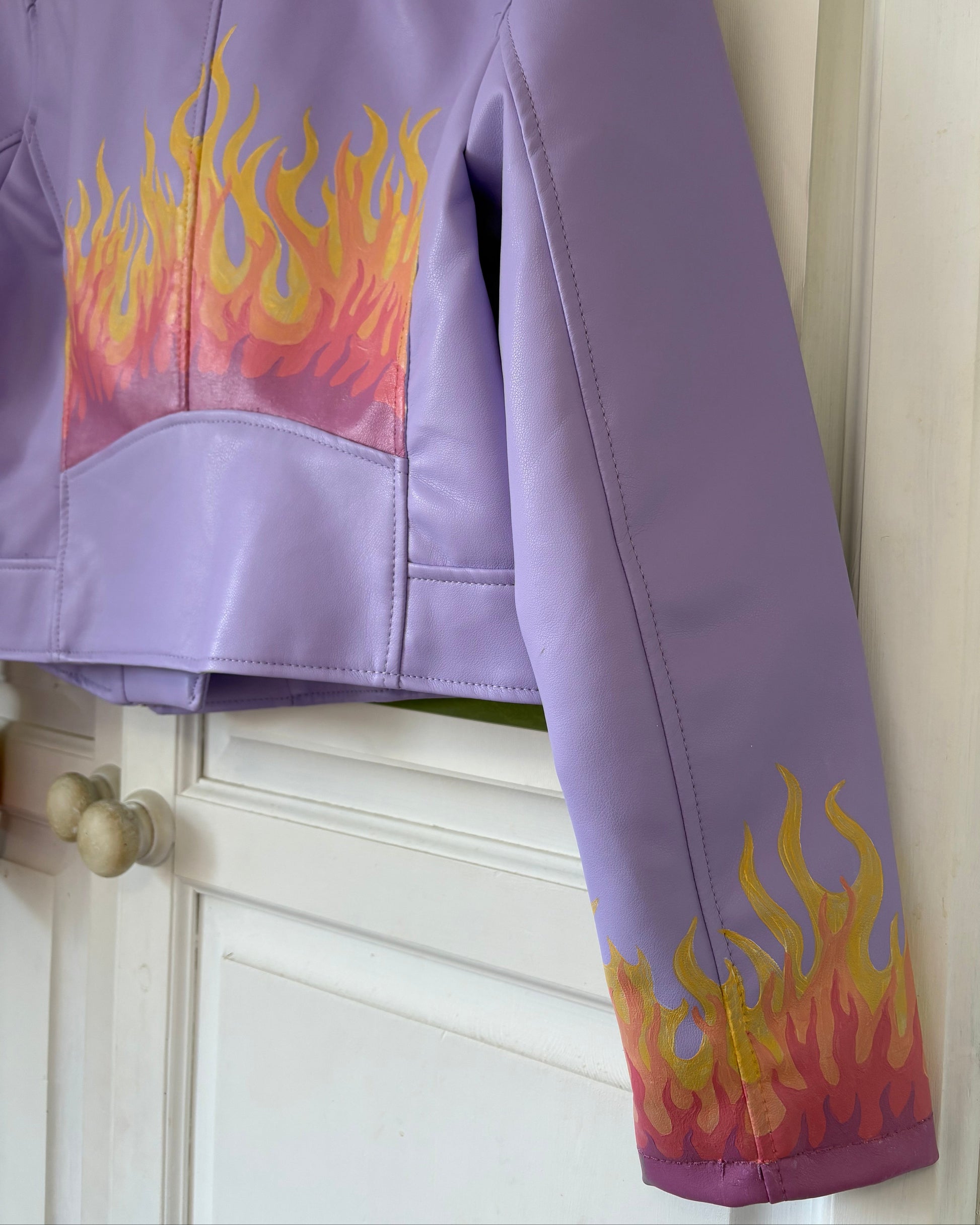 Side view of Lilac PU leather jacket with painted flame design on back and cuffs
