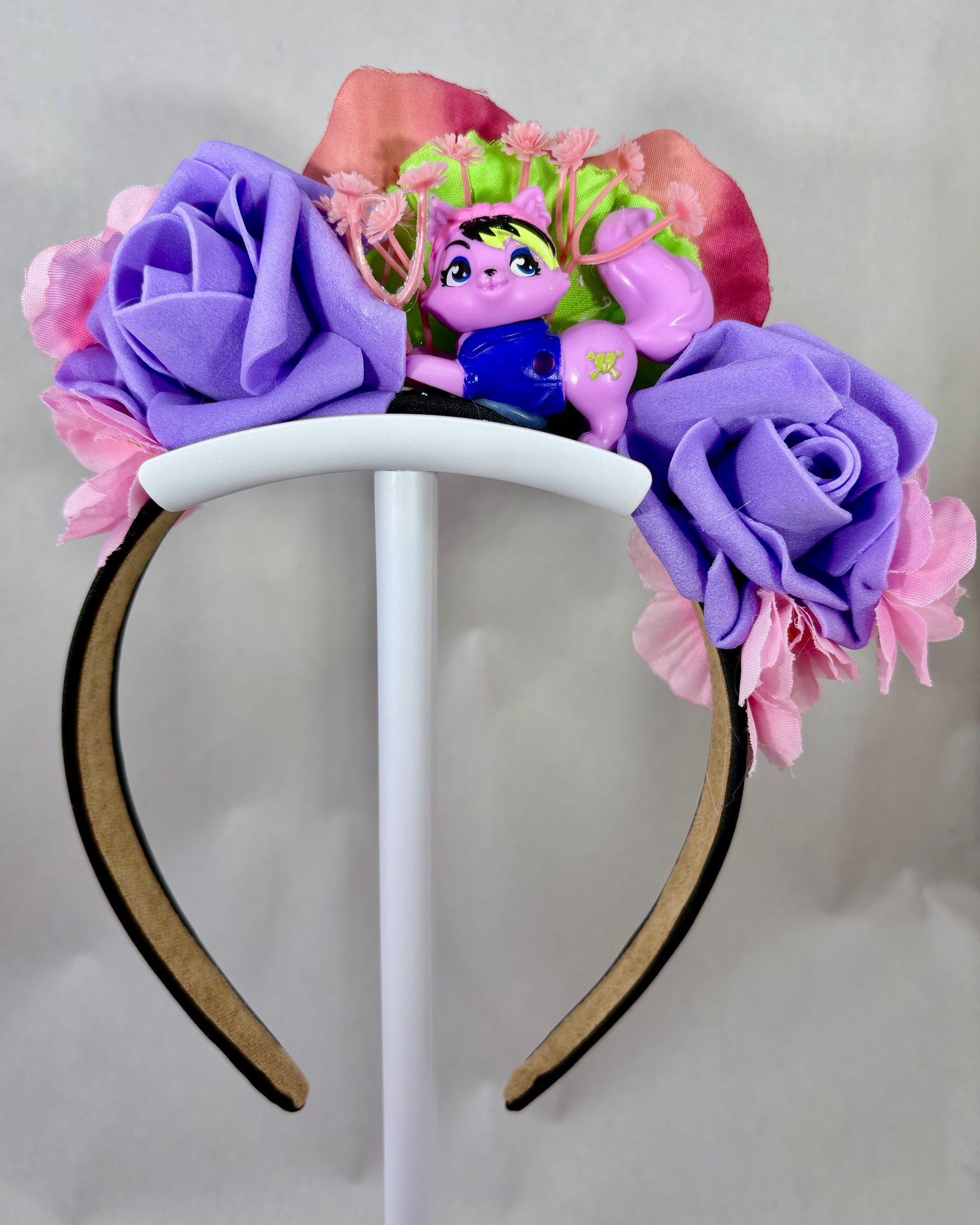 Headband with purple and pink flowers and a small pink toy cat