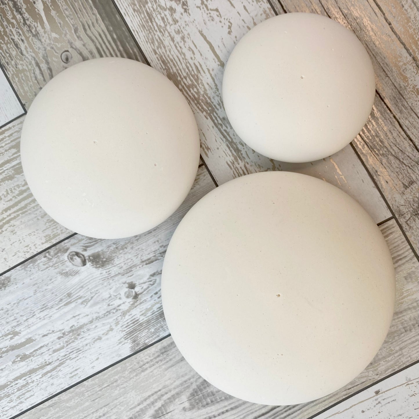 3 large white circular plaster stones of different sizes, each with a tiny centre hole to help with painting mandalas