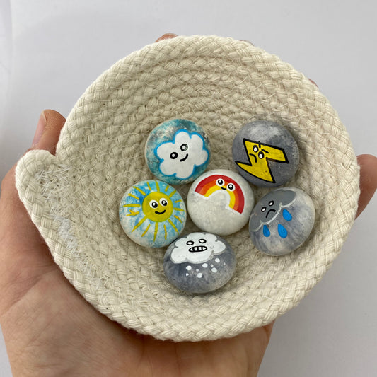 6 small hand painted weather themed pebbles in a rope bowl