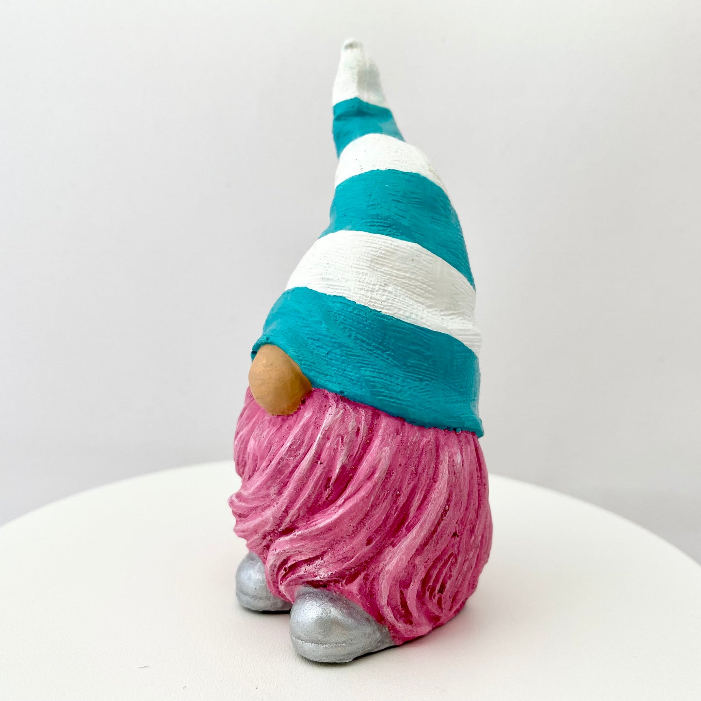 Hand painted Gonk statue with pink beard and teal and white striped hat  Edit alt text