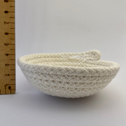 Side view of Small white rope bowl next to a ruler