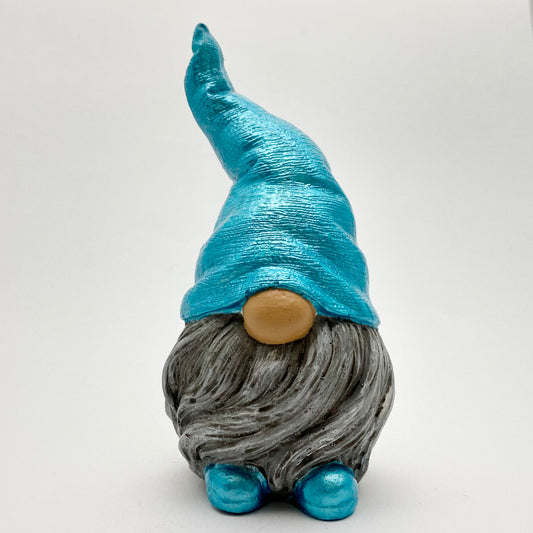 A small hand painted gonk statue with a metallic blue hat and matching shoes and a grey beard. 