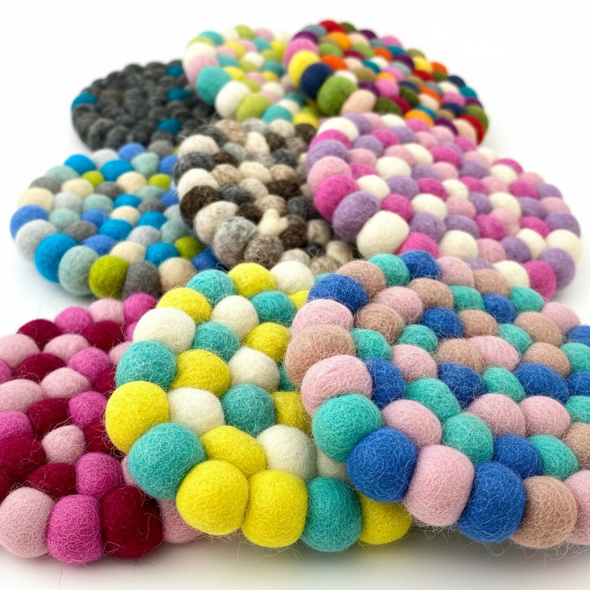 9 Coaster sized Mats made from Felt Balls in different colours. Close up showing felted texture.