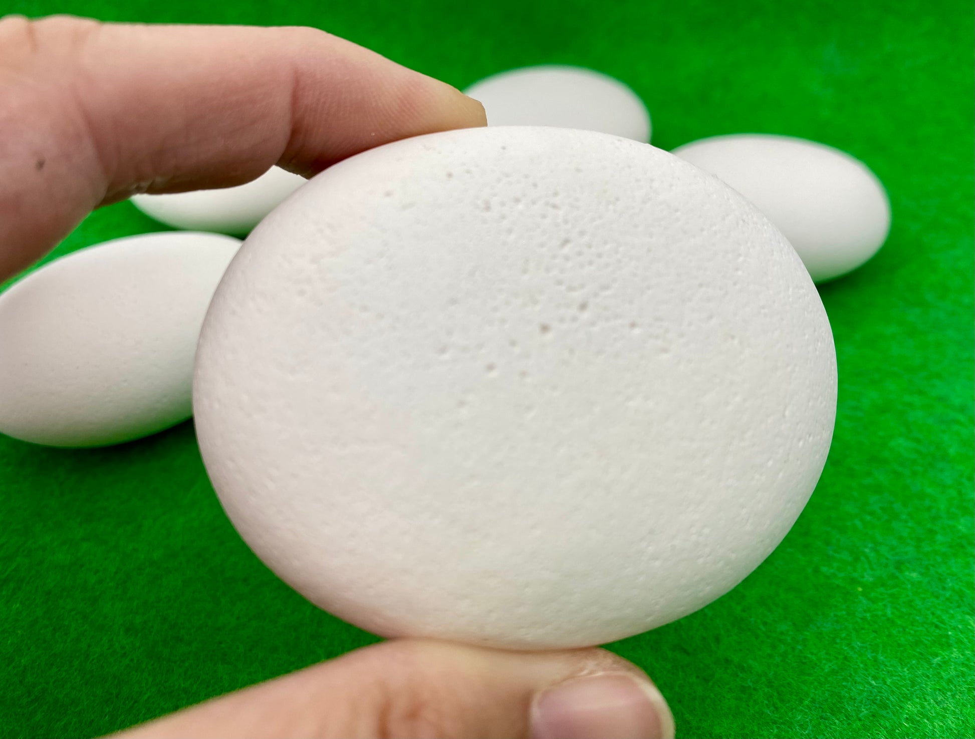 Large white plaster pebble being held