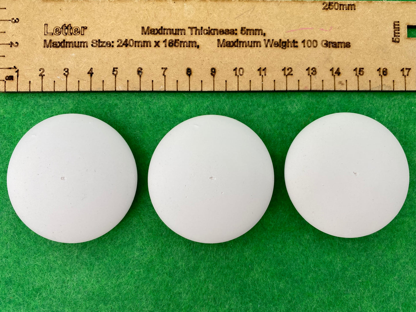 5cm white circular plaster pebbles, each with a tiny centre hole to help with painting mandalas. Photographed next to a ruler