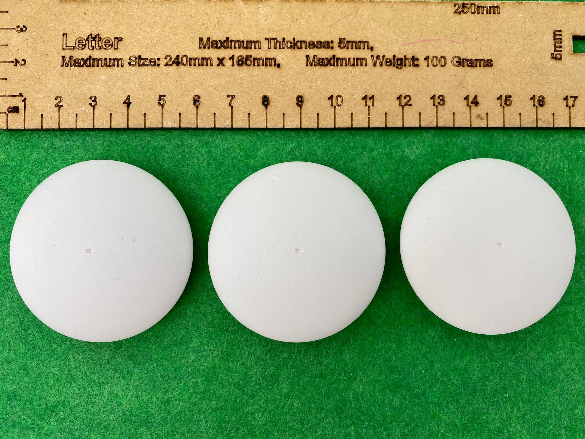5cm white circular plaster pebbles, each with a tiny centre hole to help with painting mandalas. Photographed next to a ruler