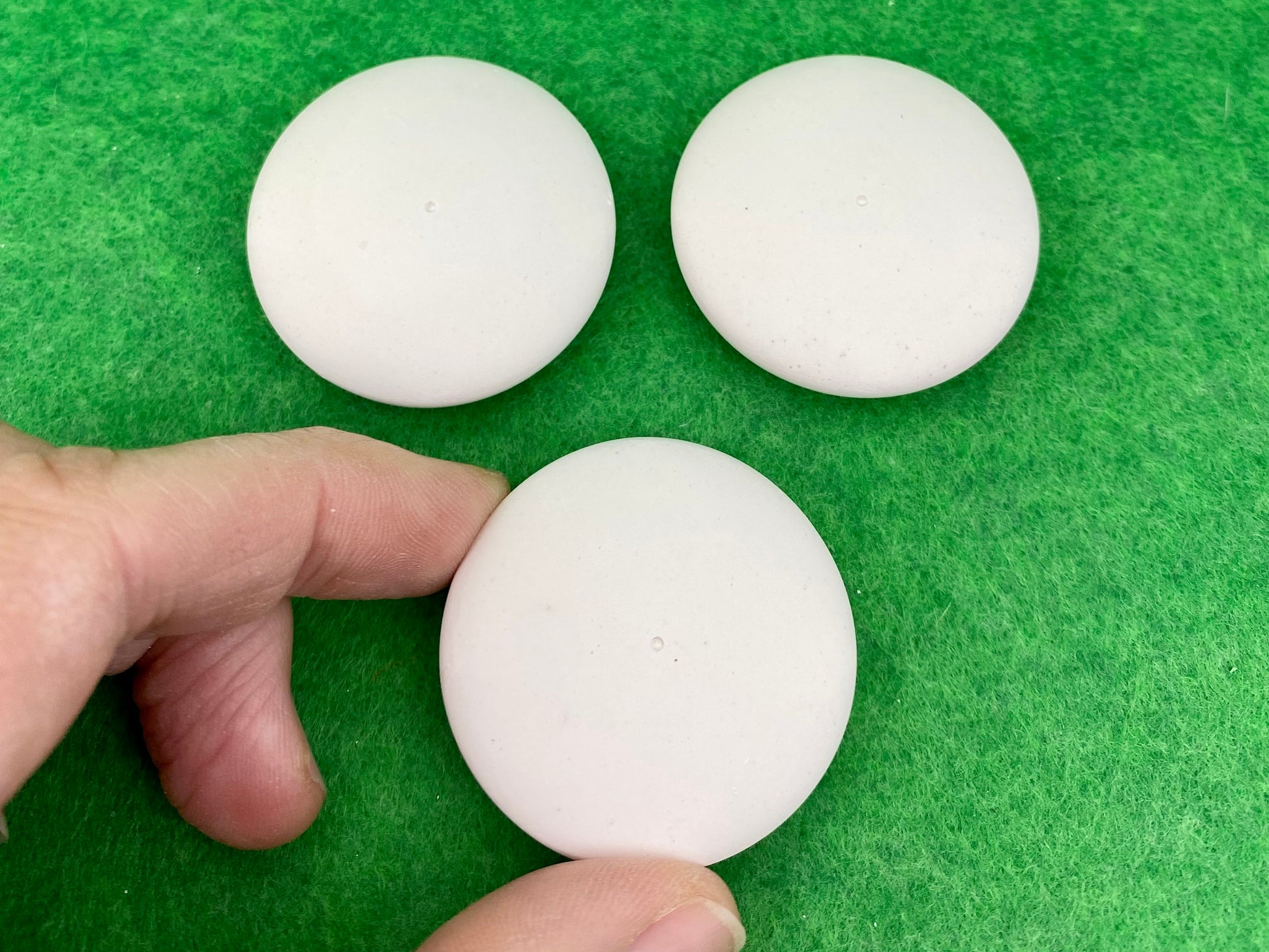 4cm white circular plaster pebbles, each with a tiny centre hole to help with painting mandalas. Photographed with a hand