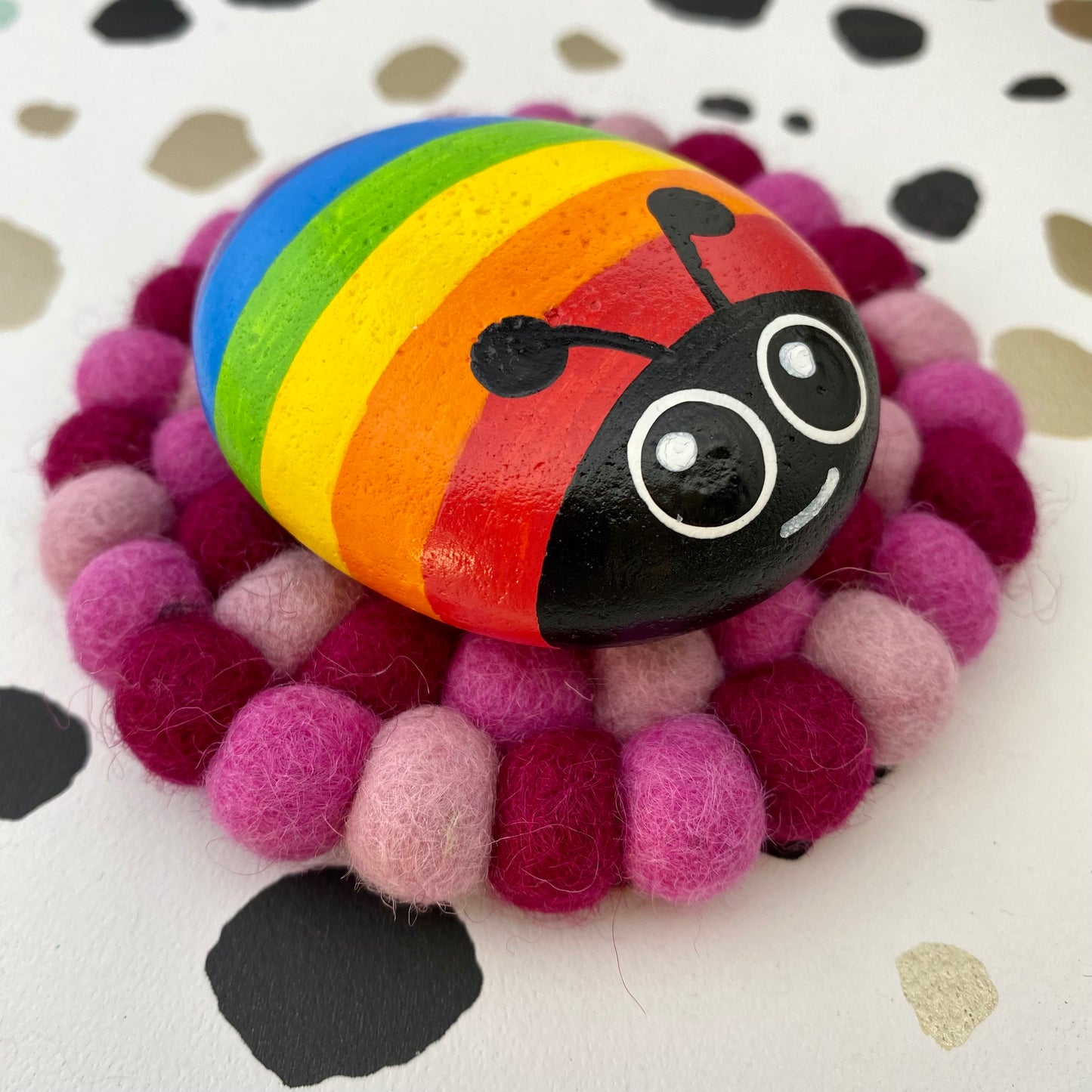 Hand painted Rainbow Bug Pebble on Pink Felt Mat