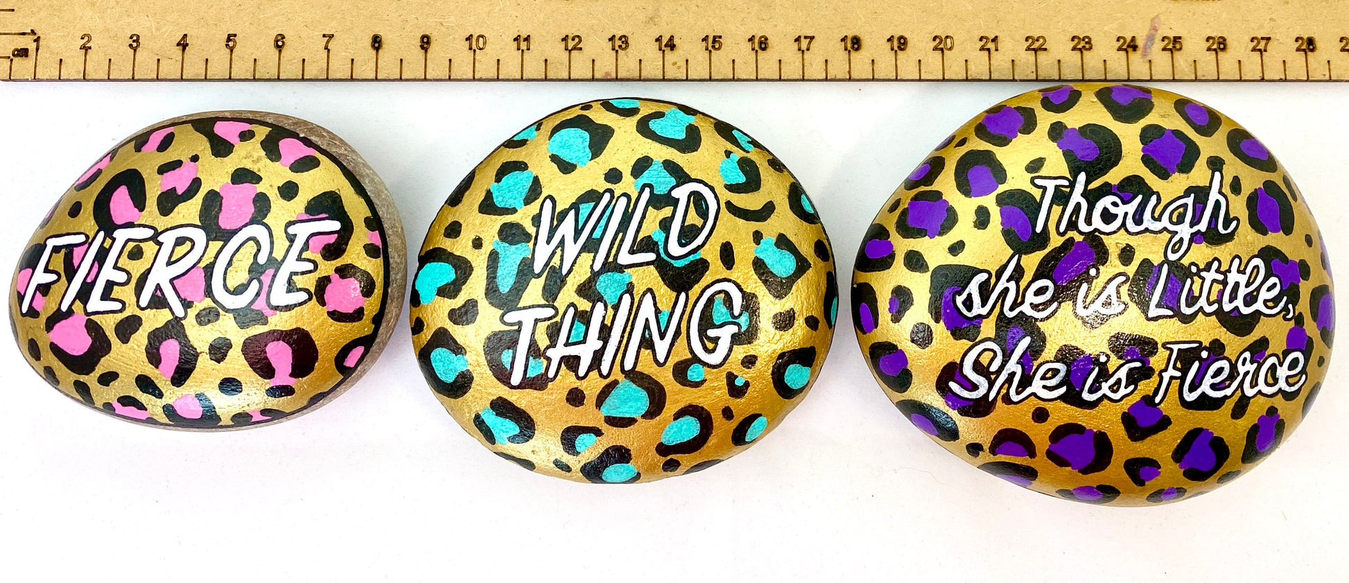 3 Hand painted Leopard Print Stone Paperweights next to a ruler