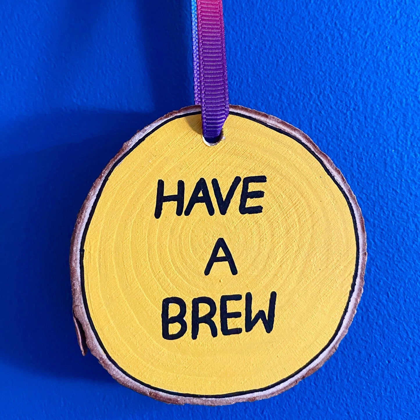 Back side of wooden slice with the words Have a Brew