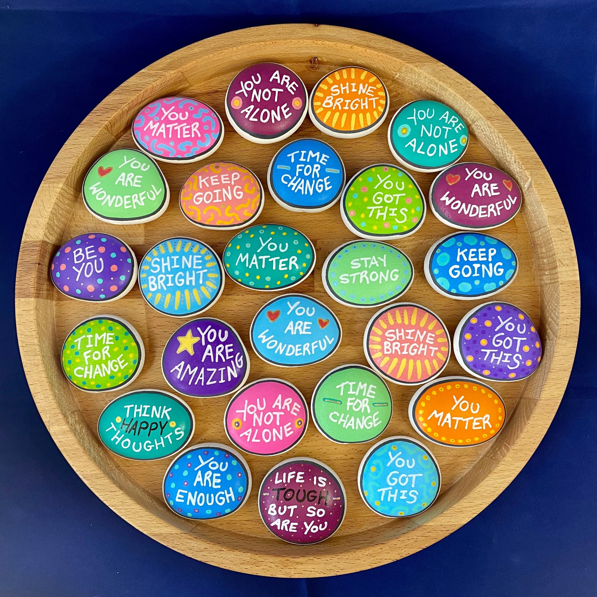 Lots of Colourful Hand painted pebbles with uplifting affirmations written on