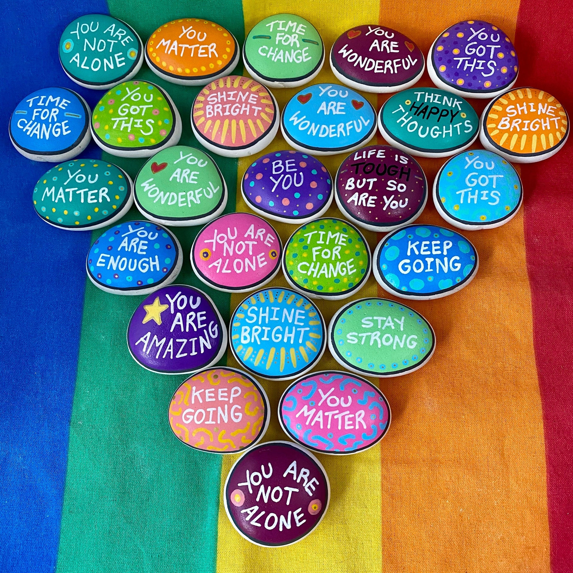 Lots of Colourful Hand painted pebbles with uplifting affirmations written on