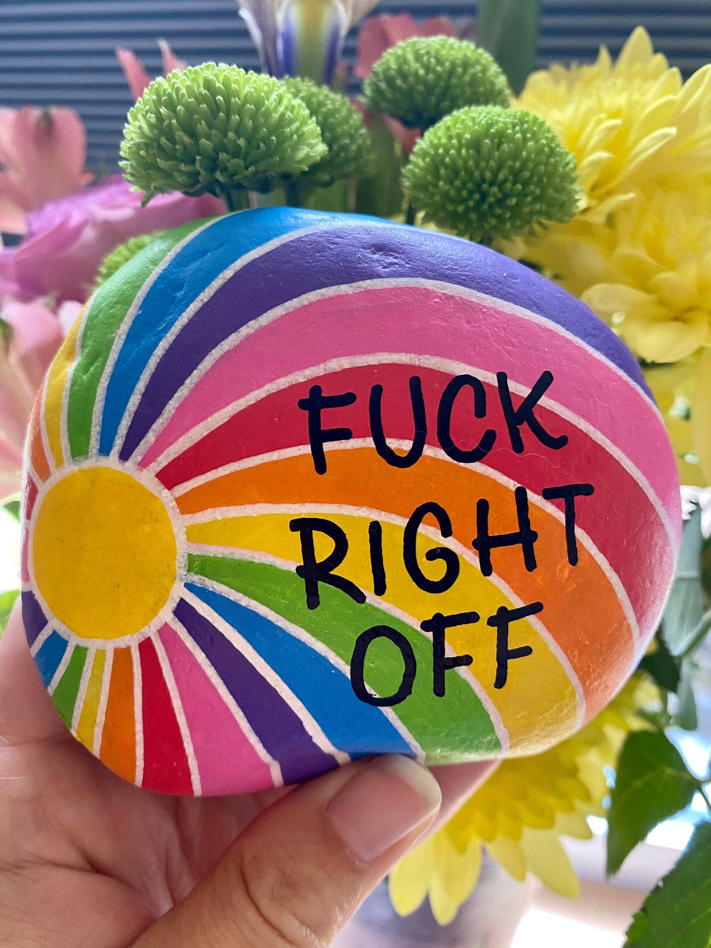 F Right Off Hand painted Rainbow Stone Paperweight with flowers behind