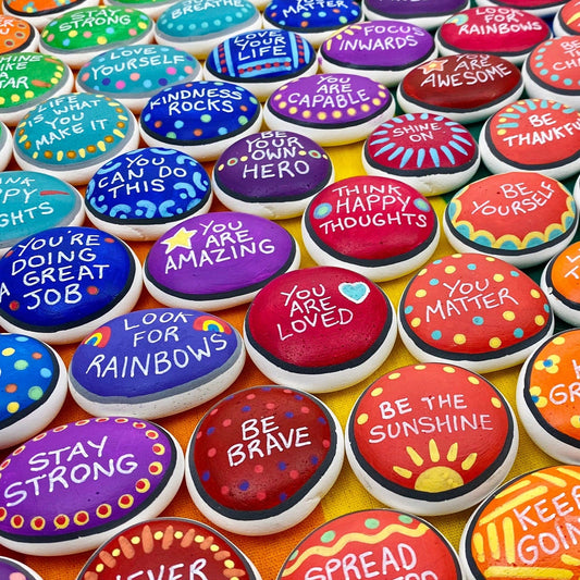 Lots of Colourful Hand painted pebbles with uplifting affirmations written on