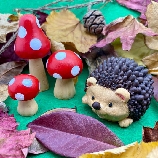 Hand painted Hedgehog and 3 red and white toadstools ornaments with autumnal leaves and pine cones in the background
